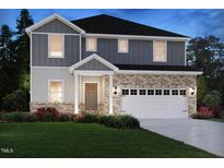 Charming two-story home featuring a brick and siding exterior, a two-car garage, and a well-manicured front yard at 1113 Landen Creek Ln, Zebulon, NC 27597