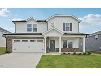 Charming two-story home with a white facade, brick accents, and a spacious two-car garage at 1121 Landen Creek Ln, Zebulon, NC 27597