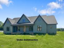 Under construction home featuring a traditional exterior, well-manicured lawn and clear blue skies at 11226 Old Beulah Rd, Kenly, NC 27542