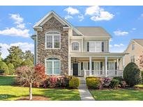 Inviting two-story home featuring a stone facade, covered porch, and beautifully landscaped front yard at 134 Barclay Valley Dr, Cary, NC 27519