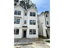 A bright, modern three-story townhome with white siding, black trim and black framed windows at 1533 Crescent Townes Way, Raleigh, NC 27604