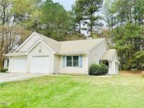 Charming single-story home featuring a two-car garage, tidy lawn, and inviting curb appeal at 203 Standish Dr, Chapel Hill, NC 27517