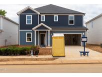 Two-story home featuring a two-car garage, a mix of blue and light blue siding, and white trim around the windows and front door at 2218 Cherry Creek Rd, Haw River, NC 27258