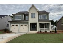 Charming two-story home boasts a two-car garage, covered porch, and lush green lawn at 2324 Eagle Shot Ct # 19, Fuquay Varina, NC 27526