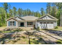 Charming single-story home with stone accents, blue shutters, and attached two car garage at 2784 Norrington Rd, Lillington, NC 27546