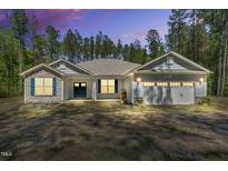 Charming single-story home with stone accents, a two-car garage, and a well-manicured yard at 2784 Norrington Rd, Lillington, NC 27546
