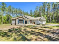 Charming single-story home with stone accents and an inviting front porch, surrounded by lush trees at 2784 Norrington Rd, Lillington, NC 27546