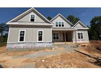 New two-story home featuring gray siding, double windows, and a covered porch with a stylish gable roofline at 348 Inspiration Way, Fuquay Varina, NC 27526