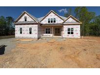 Exterior view of home under construction with windows installed and covered in building wrap with a gravel driveway at 348 Inspiration Way, Fuquay Varina, NC 27526