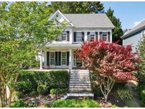Charming two-story home with a welcoming front porch and beautifully landscaped front yard at 402 Vatersay Dr, Apex, NC 27502