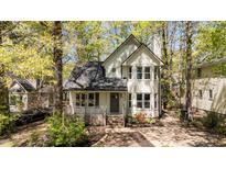 Charming two-story home with a covered front porch and mature trees surrounding the property at 4936 Liverpool Ln, Raleigh, NC 27604
