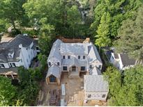 An aerial view showcases a house under construction, featuring a modern design and surrounded by lush greenery at 516 Transylvania Ave, Raleigh, NC 27609