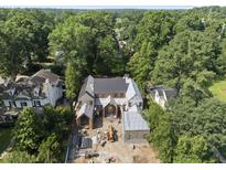 A new construction home with brick and stone facade sits on a wooded lot at 516 Transylvania Ave, Raleigh, NC 27609