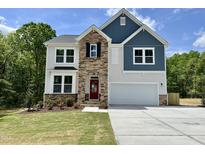 Charming two-story home featuring stone accents, a bright red front door, and an attached two-car garage at 544 Duncan Creek Rd # 151, Lillington, NC 27546