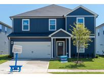 Charming blue two-story home with a well-manicured lawn and a one car garage at 630 White Birch Ln, Angier, NC 27501