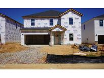New construction home featuring a two-car garage and covered entryway awaiting landscaping at 630 White Birch Ln, Angier, NC 27501
