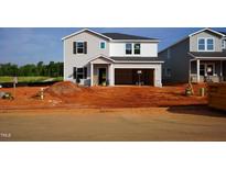 New construction home with a two-car garage and gray vinyl siding awaits its final touches at 728 Deschutes Dr, Garner, NC 27529