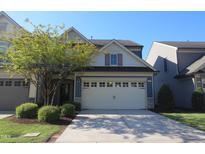Two story home featuring an attached two car garage, manicured lawn, and mature shade tree at 802 Brier Crossing Loop, Durham, NC 27703