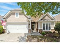 Charming home featuring a two-car garage, stone accents, and beautiful landscaping at 803 Footbridge Pl, Cary, NC 27519