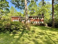 Charming brick home with a well-manicured lawn and mature trees, offering great curb appeal at 905 Cindy St, Cary, NC 27511