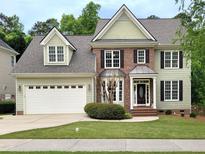 Charming two-story home with a manicured lawn, brick accents, and a two-car garage at 113 Chesterfield Dr, Cary, NC 27513
