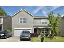 Charming two-story home with light grey siding, a well-manicured lawn, and a driveway with parking at 123 Charndon Way, Fuquay Varina, NC 27526