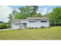 Charming home featuring a freshly painted white exterior, manicured lawn, and a welcoming blue front door at 2006 Waters Dr, Raleigh, NC 27610