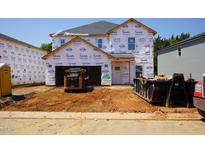 Exterior view of a home under construction with Tyvek wrap and heavy equipment at 2233 Cherry Creek Rd, Haw River, NC 27258