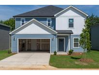 Charming two-story home featuring blue siding, a spacious two-car garage, and a well-manicured front yard at 2233 Cherry Creek Rd, Haw River, NC 27258