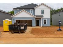 Two-story home with blue siding, white accents, and an open garage, presenting a classic, clean, and inviting facade at 2233 Cherry Creek Rd, Haw River, NC 27258