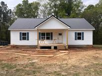 Charming single-story home featuring a metal roof, white siding, and blue shutters at 2234 Burch Bridge Rd, Burlington, NC 27217