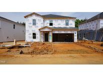 New two-story home under construction with Tyvek wrap and a two car garage at 2239 Cherry Creek Rd, Haw River, NC 27258