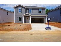 Two-story home with gray siding and a two car garage, with construction materials scattered in the front yard at 2239 Cherry Creek Rd, Haw River, NC 27258