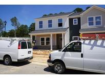 Two-story home with modern facade, large windows, and welcoming porch in a neighborhood setting at 3701 Rosebush Dr, Zebulon, NC 27597