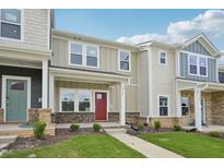 Charming townhome featuring brick accents, a red front door, and meticulously maintained landscaping at 3705 Rosebush Dr, Zebulon, NC 27597