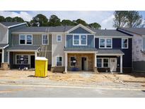 New townhomes showcase modern facades, each distinguished by varying siding colors and brick foundations at 3707 Rosebush Dr, Zebulon, NC 27597