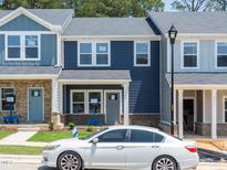 Charming townhouse featuring horizontal navy siding, gray door and brick accents at 3709 Rosebush Dr, Zebulon, NC 27597