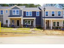 Charming, newly constructed townhomes with colorful facades and inviting front lawns at 3709 Rosebush Dr, Zebulon, NC 27597