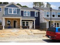 Newly constructed townhomes showcase a modern design with varying colors and brick foundations at 3709 Rosebush Dr, Zebulon, NC 27597