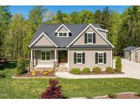Charming home featuring a manicured lawn, stone accents, and inviting front porch at 3805 Watermark Dr, Franklinton, NC 27525