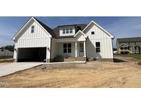 Beautifully designed two-story home featuring vertical siding, an attached garage and a welcoming front porch at 3820 Fairway View Dr # 16, Fuquay Varina, NC 27526