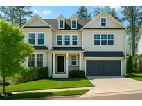 Charming two-story home boasts a well-manicured lawn and an attached two-car garage at 5265 Aleppo Ln, Raleigh, NC 27613