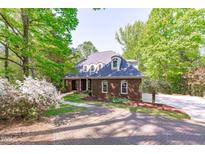 Charming brick home with a beautiful paved driveway and well-maintained landscaping at 5504 Spring Bluffs Ln, Raleigh, NC 27606