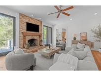 Inviting living room featuring a stone fireplace, hardwood floors and natural light at 5504 Spring Bluffs Ln, Raleigh, NC 27606