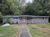 Charming single-story home with a classic white door and freshly painted gray siding at 66 Toomer Loop Rd, Pittsboro, NC 27312