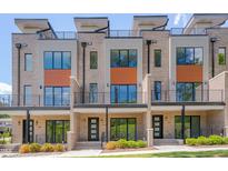 Modern townhomes showcasing a brick facade, balconies, and sleek black metal railings at 1012 Manor Way, Durham, NC 27701