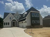 New construction shows a two-story home with a three-car garage and a combination of siding and brick exterior at 1021 Azalea Garden Cir, Raleigh, NC 27603