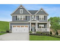 Charming two-story home with gray siding, white trim, and a welcoming front porch at 1044 Country Pasture Cv, Wendell, NC 27591