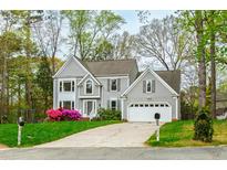 Charming two-story home featuring gray siding, attached garage, and colorful landscaping at 1412 Amberton Ct, Raleigh, NC 27615