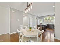 Bright dining area features hardwood floors and an elegant light fixture, perfect for entertaining at 2027 Hayes Ln, Holly Springs, NC 27540